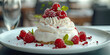 Delicious Pavlova cake with alternating layers of whipped cream and meringue topped with fresh berries raspberries.