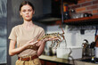 Woman holding a lobster in her hand in a home kitchen environment