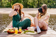a woman is taking a picture of another woman having a picnic