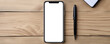 Smartphone on wooden desk with pen and pad