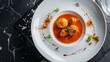 Authentic ghanaian dish with dumplings in a spicy tomato sauce, garnished with fresh herbs on a white plate, fine dining presentation