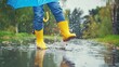 © lililia - a child, adorned in vibrant rain boots, leaps into puddles with an umbrella in hand, creating a playful cascade of splashing water.