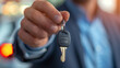 © Luluraschi - Close-up of salesman holding new car key in a car dealership, acquisition
