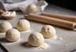 Dough balls on a floured surface with a rolling pin in the background