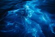 © dreamdes - Bioluminescent water glowing at night. Bioluminescence, the glow of marine plankton. Fluorescent particles. Summer travel and tourism concept. Abstract background for wallpaper, design