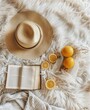 Open Book, Oranges, and Straw Hat on White Blanket