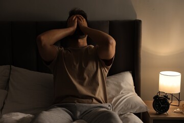 Wall Mural - Man suffering from headache on bed at home