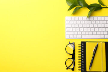 Sticker - Office stationery, glasses, computer keyboard and green leaves on yellow background, flat lay. Space for text