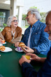 © CarlosBarquero - Vertical. Mature gray hair friends group at coffee and bakery bar. Caucasian senior citizens people talking and having fun together at cappuccino restaurant. Life style of happy at cafe terrace