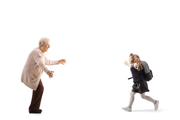 Poster - Full length profile shot of a schoolgirl with a backpack running towards an elderly woman