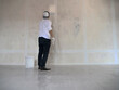 Asian male painter painting new white wall with roller brush, house interior renovation