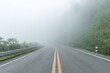 Asphalt road to mountain with fog