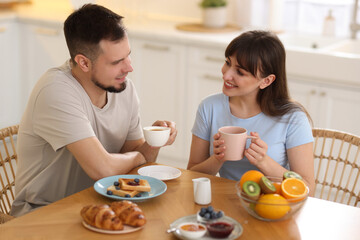 Wall Mural - Happy couple having tasty breakfast at home