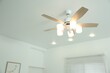 Ceiling fan with lamps indoors, low angle view