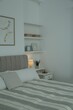 Large bed, pictures and shelves with accessories in stylish bedroom
