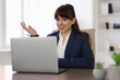 © New Africa - Woman using video chat during webinar at wooden table in office