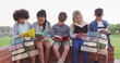 Image of books moving over happy diverse school kids reading book at school