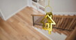 Image of gold key and house key ring over blurred house interior