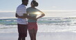 Image of light trails over african american couple at beach