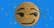 Digital image of golden confetti falling over smirk face emoji against blue background