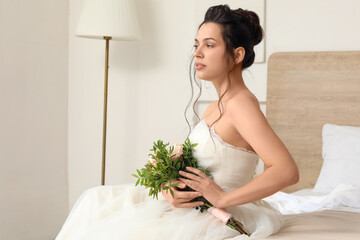 Poster - Young bride with wedding bouquet sitting in bedroom