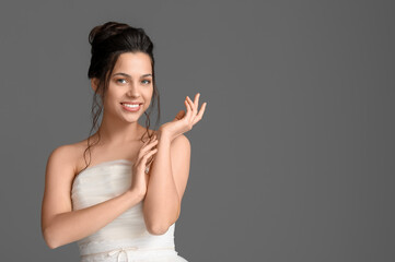 Wall Mural - Beautiful young bride in wedding dress on dark background