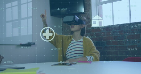 Poster - Image of financial data processing with icons over biracial businesswoman using vr headset