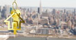 Image of gold house key and fob over out of focus cityscape