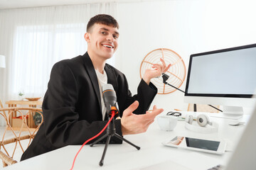 Poster - Young man recording podcast at table in studio