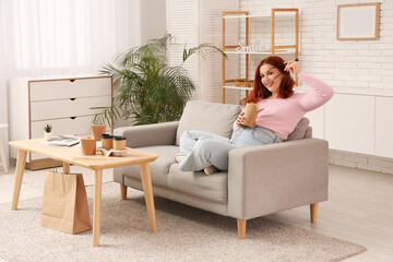 Canvas Print - Young woman eating Asian food on sofa at home