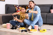 © Pixel-Shot - Happy little boy with his father playing video game at home