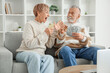 © Pixel-Shot - Mature couple with money and mobile phone at home