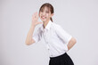 Asian woman in university student uniform with open mouths raising hands shouting good news isolated on white background.