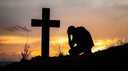 Wall Mural - Silhouette of a figure kneeling in prayer before the cross in deep reverence