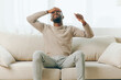 © SHOTPRIME STUDIO - A tired African American man sitting on a couch at home, feeling stressed and frustrated due to a headache He appears sick and overwhelmed, showing signs of physical and mental fatigue A sense of