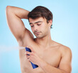 Grooming, man and deodorant in morning, routine and wellness in body care, hygiene and blue background. Male person, cosmetics and fresh as confident, masculine and fragrance with product in studio
