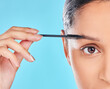 Portrait, eyebrows and girl with mascara makeup for beauty, cosmetics product or wellness in studio. Woman, model or half face closeup with brush, skincare or application results on blue background