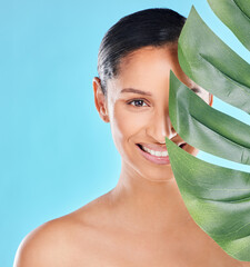 Poster - Woman, portrait and palm leaf with skincare glow from spa treatment and natural cosmetics. Model, skin and face of person relax for dermatology detox in a studio with blue background feeling healthy