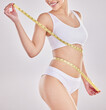 Progress, underwear and woman with tape measure on stomach for wellness, digestion and lose weight. Smile, abdomen and healthy gut of model in studio on white background for belly slimming or figure