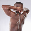Black man, fitness and back with stretching in studio for skincare, body health and dermatology. Male person, bodybuilder and relax on white background with smooth skin, self care and satisfaction