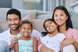 © peopleimages.com - Smile, happiness and portrait of family on sofa in living room for care, love and bonding together in home. Embrace, parents and girl children on couch for relax, having fun or weekend break in house