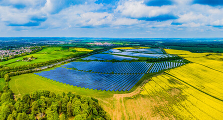 Panoramic Aerial shot of large solar farm surrounded by farmer's fields