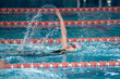 Swimmer child swims backstroke swimming style in the pool