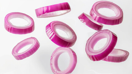 Floating raw red onion rings on white background