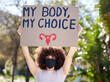 Woman, portrait and poster for outdoor protest on abortion, body choice or freedom of human rights. Feminism, cardboard and female person with mask for equality, political change or safe decision