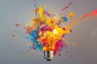 Light bulb exploding with bright paint splashes, creative concept