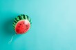 Air balloon in the shape and color of juicy watermelon slice on bright blue background