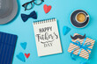 Happy Father's day concept with notebook, coffee cup and gift box on blue background. Top view, flat lay