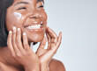 Happy black woman, skincare and facial with cream for beauty or moisturizer on a white studio background. Face of African, female person or model with smile for lotion, cosmetics or healthy skin