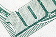 Macro image of one hundred US Dollar bill with description: 100